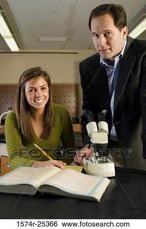 Stock Photograph - Student with her teacher in a science lab. Fotosearch