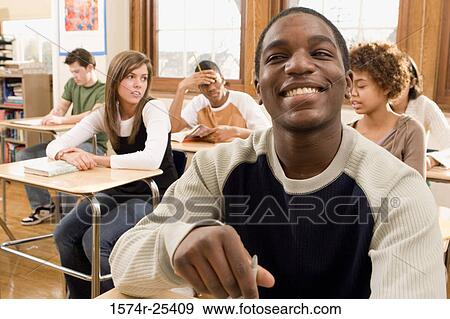 Students sitting at desks in a classroom View Large Photo Image Stock Photo - Students sitting at desks in a classroom. Fotosearch