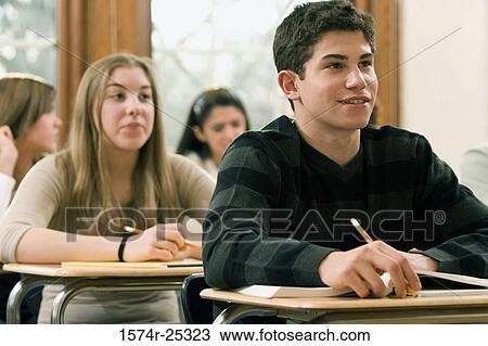 Stock Image - Students sitting at their desks in a classroom. Fotosearch