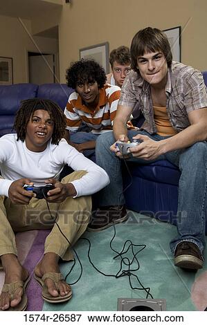 Teenage boy and a young man playing a video game View Large Photo Image Stock Photo - Teenage boy and a young man playing a video game. Fotosearch