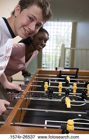 Teenage boy and a young woman playing foosball View Large Photo Image Stock Photo - Teenage boy and a young woman playing foosball. Fotosearch