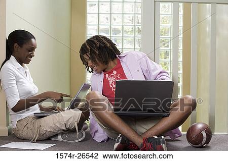 Teenage boy and a young woman using laptops View Large Photo Image Stock Image - Teenage boy and a young woman using laptops. Fotosearch