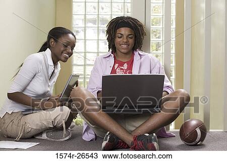 Teenage boy and a young woman using laptops View Large Photo Image Stock Image - Teenage boy and a young woman using laptops. Fotosearch