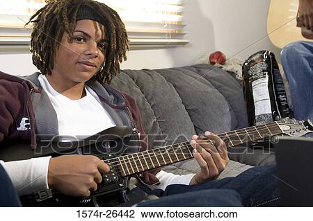 Teenage boy playing a guitar View Large Photo Image Stock Image - Teenage boy playing a guitar. Fotosearch