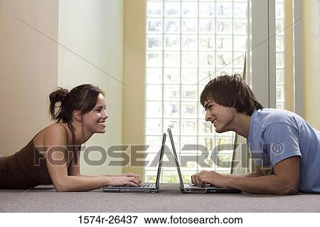 Teenage girl and a young man using laptops View Large Photo Image Stock Photo - Teenage girl and a young man using laptops. Fotosearch