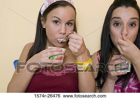 Stock Photograph - Teenage girl and a young woman eating. Fotosearch