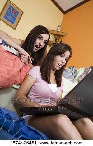 Teenage girl and a young woman using a laptop View Large Photo Image Stock Image - Teenage girl and a young woman using a laptop. Fotosearch
