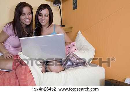 Teenage girl and a young woman using a laptop View Large Photo Image Stock Image - Teenage girl and a young woman using a laptop. Fotosearch
