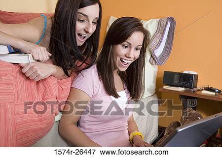 Teenage girl and a young woman using a laptop View Large Photo Image Stock Photo - Teenage girl and a young woman using a laptop. Fotosearch