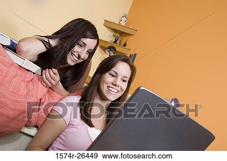 Stock Photo - Teenage girl and a young woman using a laptop. Fotosearch