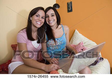 Teenage girl and a young woman using a laptop View Large Photo Image Stock Photography - Teenage girl and a young woman using a laptop. Fotosearch