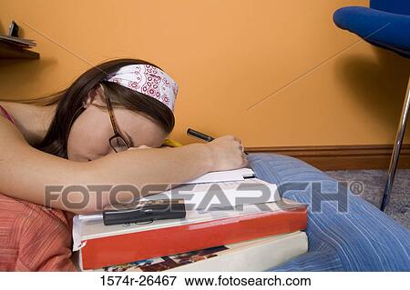 Stock Photo - Teenage girl sleeping on textbooks. Fotosearch