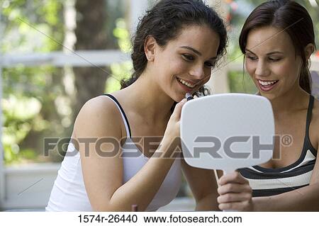 Teenage girls applying make-up View Large Photo Image Stock Image - Teenage girls applying make-up. Fotosearch