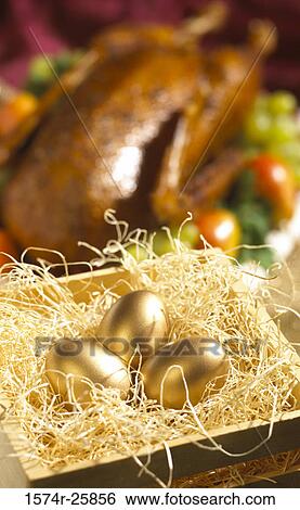 Three golden eggs in a wood crate with a cooked goose in the background View Large Photo Image Stock Photograph - Three golden eggs in a wood crate with a cooked goose in the background. Fotosearch