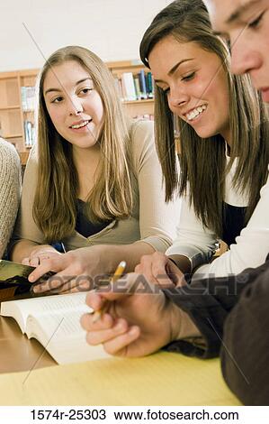 Three students in a library studying View Large Photo Image Stock Image - Three students in a library studying. Fotosearch