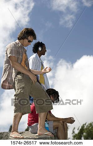 Three young men on a rock View Large Photo Image Stock Photo - Three young men on a rock. Fotosearch