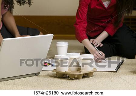 Two businesswoman sitting on the floor and working View Large Photo Image Stock Image - Two businesswoman sitting on the floor and working. Fotosearch