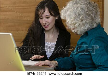 Stock Image - Two businesswomen talking. Fotosearch