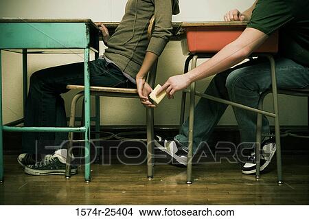 Two students passing a note in a classroom View Large Photo Image Picture - Two students passing a note in a classroom. Fotosearch