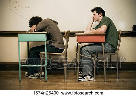 Stock Image - Two students sitting at desks in a classroom. Fotosearch