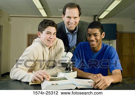 Stock Image - Two students with their teacher in a science lab. Fotosearch