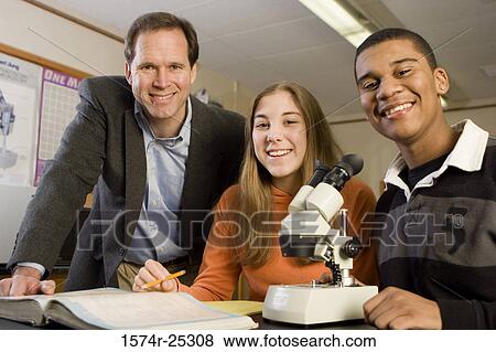 Stock Photo - Two students with their teacher in a science lab. Fotosearch