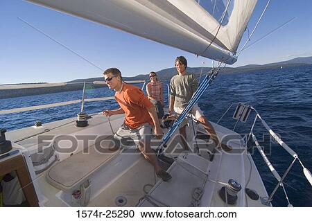 Two young men and a young woman on a sailboat View Large Photo Image Stock Image - Two young men and a young woman on a sailboat. Fotosearch