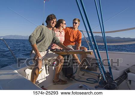 Two young men and a young woman sitting on the edge of a sailboat View Large Photo Image Stock Image - Two young men and a young woman sitting on the edge of a sailboat. Fotosearch