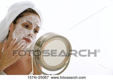 Young adult woman applying cleanser to her face View Large Photo Image Stock Photo - Young adult woman applying cleanser to her face. Fotosearch