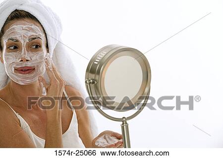 Young adult woman applying cleanser to her face View Large Photo Image Stock Photograph - Young adult woman applying cleanser to her face. Fotosearch