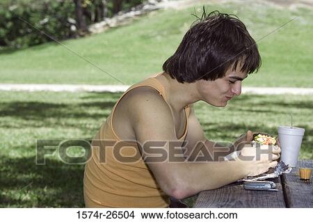 Young man eating View Large Photo Image Picture - Young man eating. Fotosearch