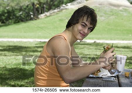Young man eating View Large Photo Image Stock Photography - Young man eating. Fotosearch