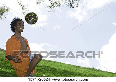 Young man kicking a soccer ball View Large Photo Image Picture - Young man kicking a soccer ball. Fotosearch