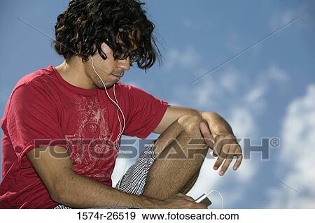 Young man listening to music View Large Photo Image Stock Photo - Young man listening to music. Fotosearch
