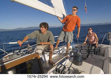 Young man turning handle of a cable winch with another young man standing behind him View Large Photo Image Picture - Young man turning handle of a cable winch with another young man standing behind him. Fotosearch