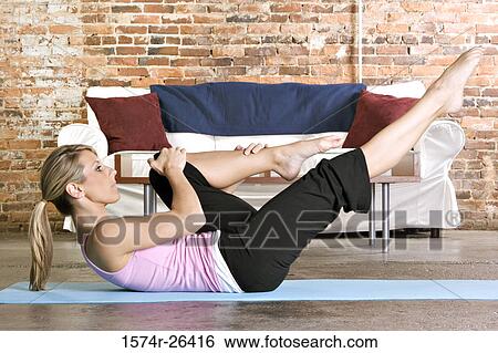 Young woman exercising on an exercise mat View Large Photo Image Stock Photograph - Young woman exercising on an exercise mat. Fotosearch