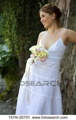 Young woman holding a bouquet of flowers and smiling View Large Photo Image Stock Image - Young woman holding a bouquet of flowers and smiling. Fotosearch