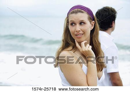 Young woman looking away with a mid adult man standing beside her View Large Photo Image Stock Photo - Young woman looking away with a mid adult man standing beside her. Fotosearch