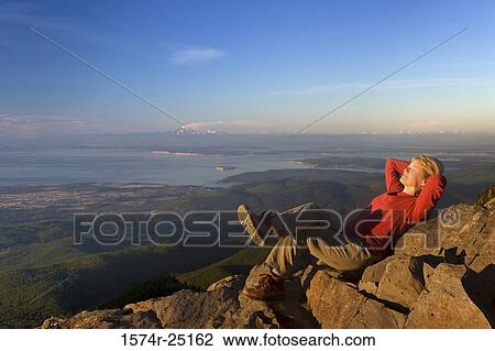 Young woman lying on rocks View Large Photo Image Stock Image - Young woman lying on rocks. Fotosearch