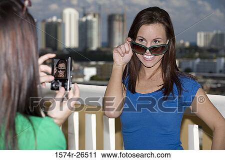 Young woman photographing a teenage girl View Large Photo Image Stock Image - Young woman photographing a teenage girl. Fotosearch