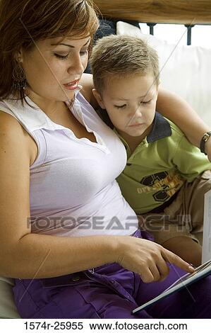 Young woman reading to her son in the bedroom View Large Photo Image Stock Photography - Young woman reading to her son in the bedroom. Fotosearch