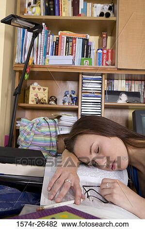Stock Image - Young woman sleeping on a textbook. Fotosearch