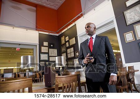 A well-dressed businessman standing in an office View Large Photo Image Stock Photo - A well-dressed businessman standing in an office. Fotosearch
