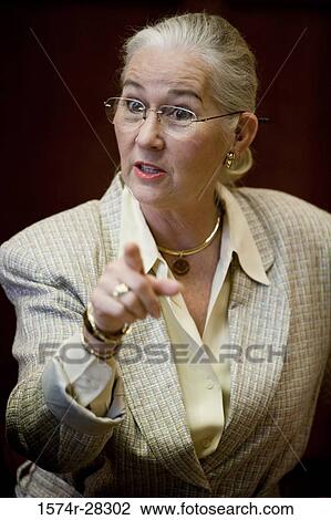 Stock Image - Angry businesswoman pointing in an office. Fotosearch