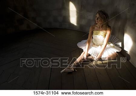 Ballet dancer sitting on hardwood floor View Large Photo Image Picture - Ballet dancer sitting on hardwood floor. Fotosearch