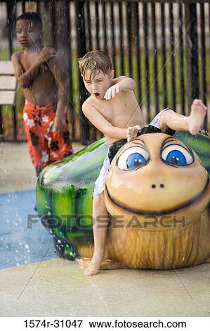 Stock Photo - Bare chested boy sitting on a tortoise sculpture. Fotosearch