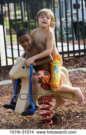 Bare chested boys sitting on spring horse View Large Photo Image Picture - Bare chested boys sitting on spring horse. Fotosearch
