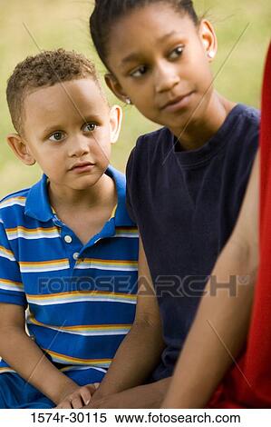 Stock Photography - Boy and girl looking away at park. Fotosearch