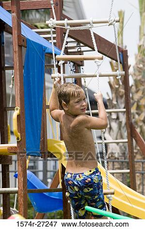 Boy climbing rope ladder and looking over shoulder View Large Photo Image Stock Photo - Boy climbing rope ladder and looking over shoulder. Fotosearch
