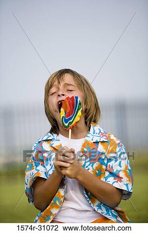 Boy eating lollipop View Large Photo Image Stock Image - Boy eating lollipop. Fotosearch